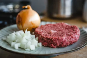 Close-up of ground beef mixed with milk in a bowl, demonstrating the tenderizing technique for juicier meat dishes.