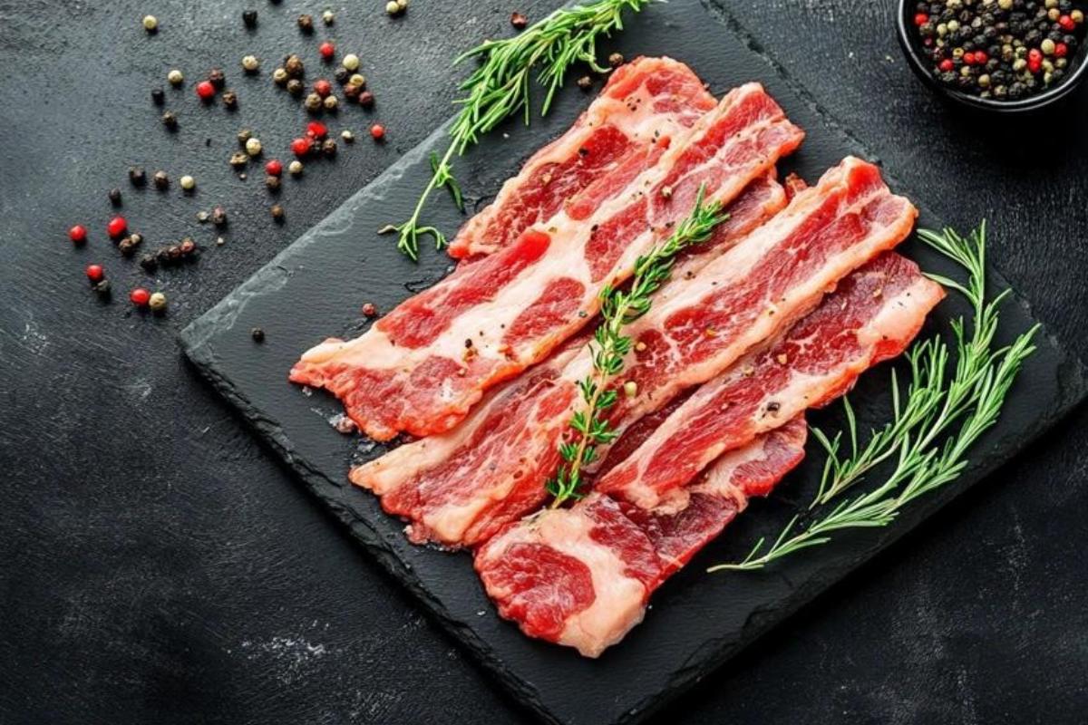 A plate of crispy beef bacon strips on a wooden table, showcasing a healthier alternative to traditional pork bacon.