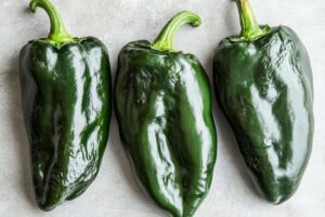 "Roasted poblano peppers with vibrant green skin, rich in vitamins and antioxidants"

